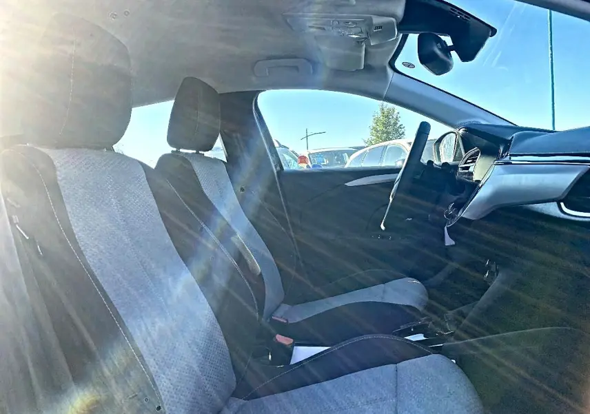 Vue intérieure côté droit de l’Opel Corsa 2025, sièges tissu noir et gris, volant multifonction et tableau de bord moderne.