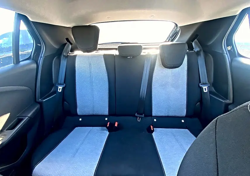 Vue intérieure arrière de la banquette arrière bicolore noire et grise de l’Opel Corsa 2025 avec appuie-têtes et ceintures visibles.
