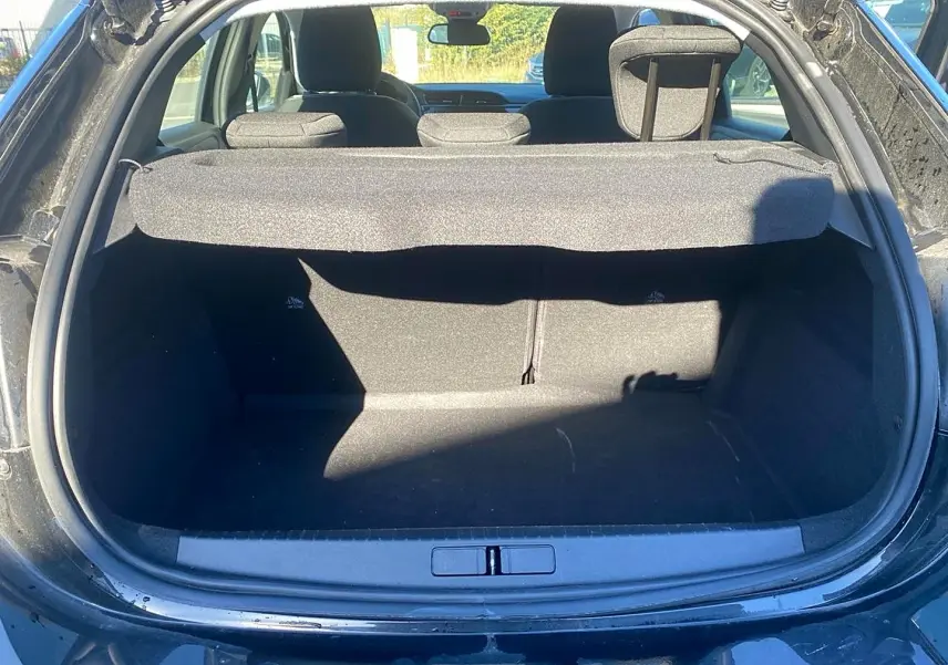 Coffre ouvert vu de l'arrière d'une Opel Corsa noire 2025, avec cache-bagages et banquette arrière visible.