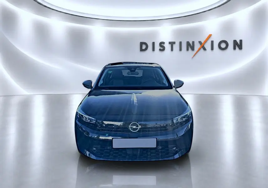 Opel Corsa noire vue de face dans un showroom lumineux avec logo Distinxion en arrière-plan.