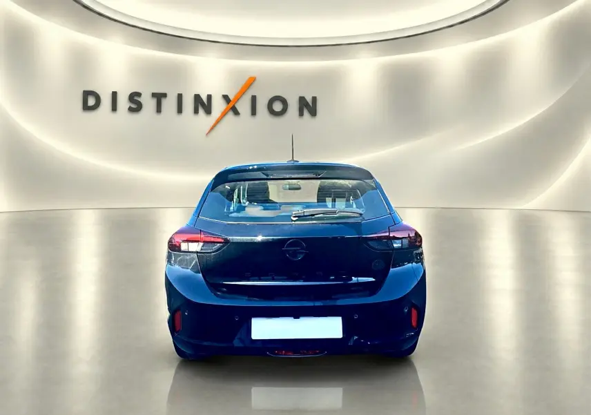 Vue arrière d'une Opel Corsa noire 2025 dans un showroom avec logo Distinxion en arrière-plan.