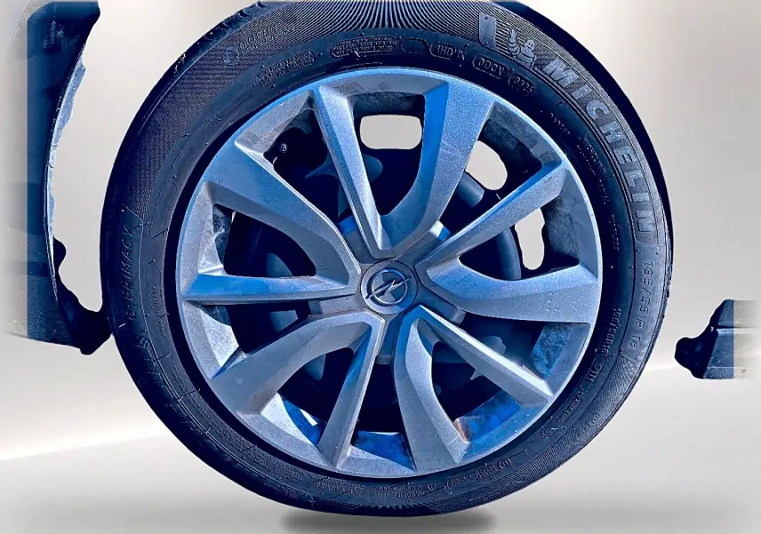 Gros plan sur la roue avant droite d’une Opel Corsa noire avec jante alliage et pneu Michelin.