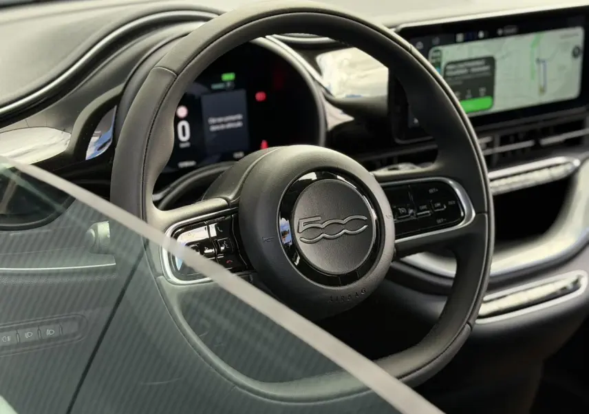 Vue rapprochée du volant noir Soft-Touch et du tableau de bord numérique de la Fiat 500 électrique 2024.