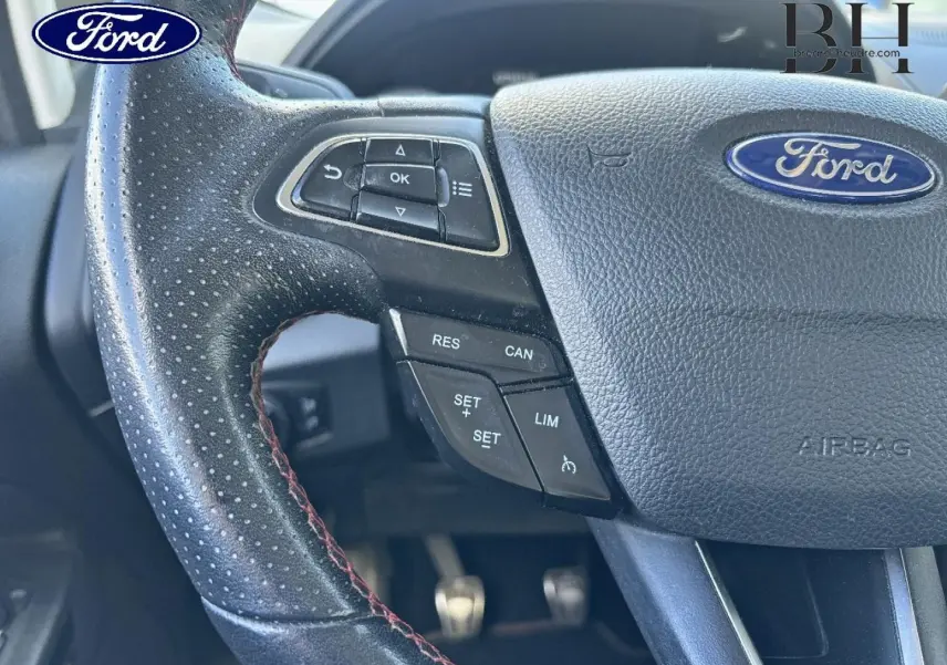 Gros plan sur le volant cuir noir perforé avec commandes multifonctions du Ford EcoSport bleu Lightning 2018.