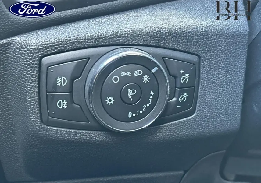 Gros plan sur le bouton de réglage des phares du Ford EcoSport 2018, intérieur noir texturé.