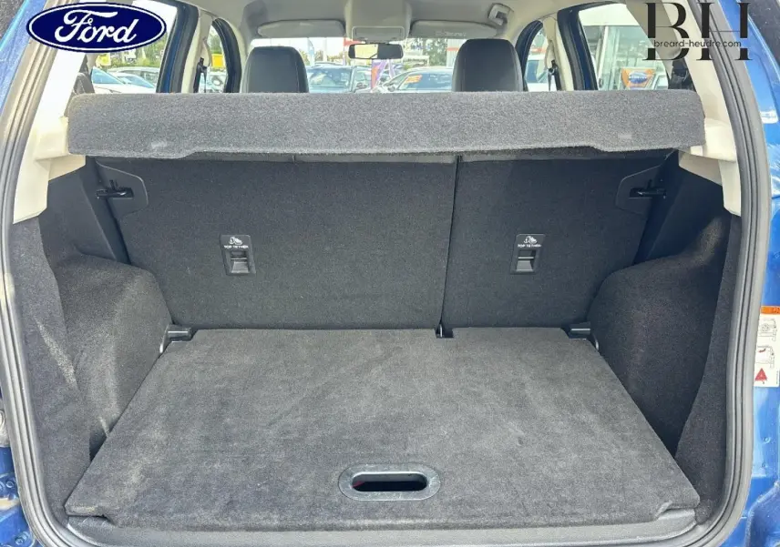 Vue arrière du coffre ouvert d’un Ford EcoSport bleu Lightning, montrant l’espace de chargement et la banquette arrière noire.