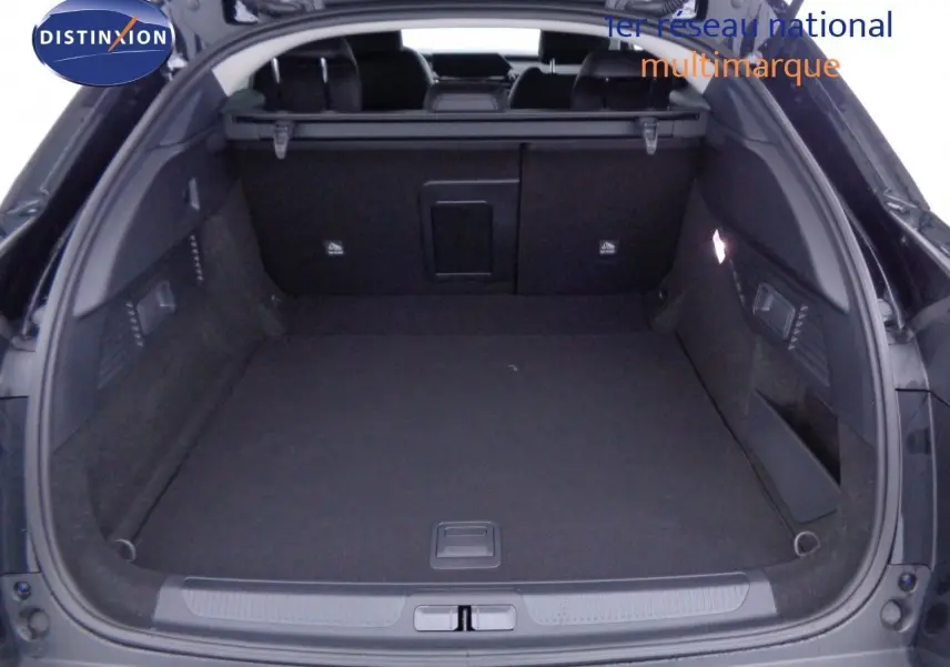 Coffre ouvert vu de l'arrière d'une Citroën C5 X noir métal, montrant un espace de chargement spacieux et bien fini.