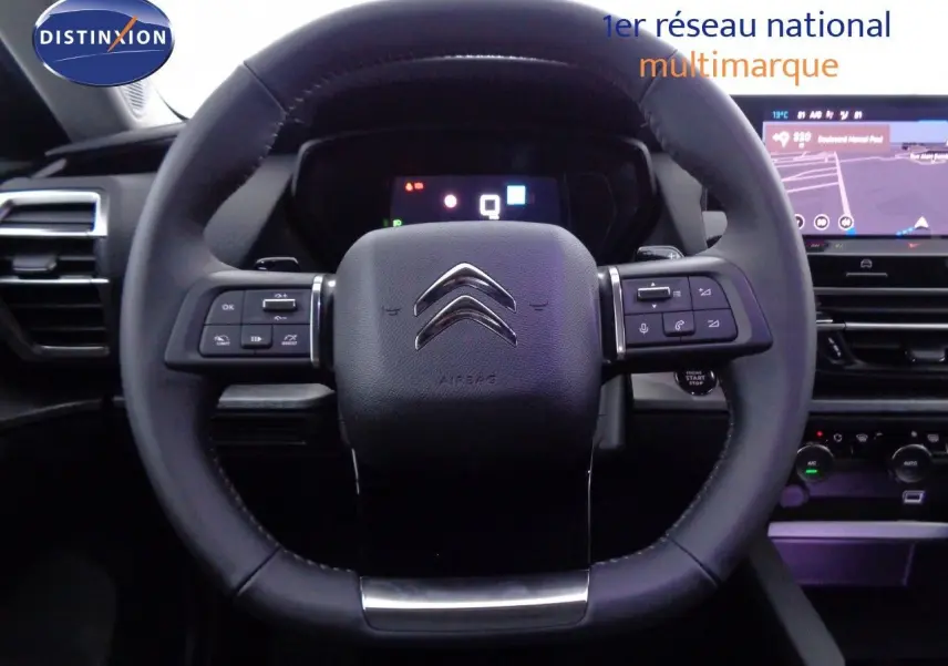 Vue rapprochée du volant noir cuir de la Citroën C5 X 2022 avec commandes intégrées et tableau de bord numérique.