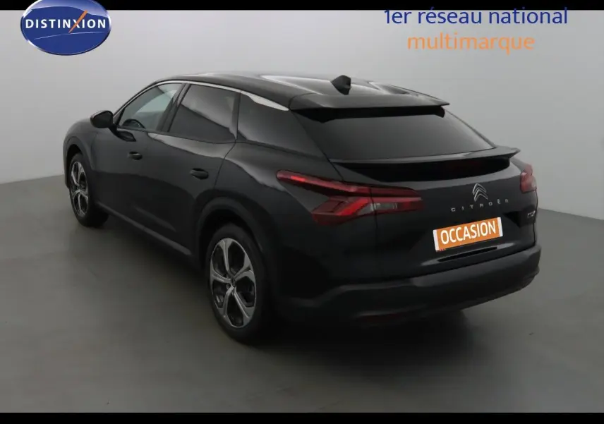 Vue 3/4 arrière gauche d'une Citroën C5 X noire métal avec feux arrière LED et jantes bi-ton.