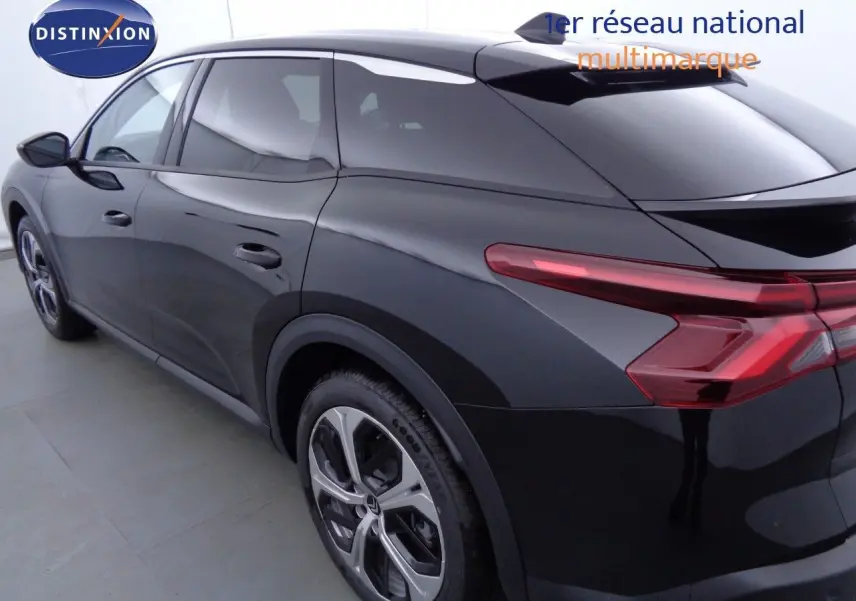 Vue 3/4 arrière droite d'une Citroën C5 X noire métal avec feux arrière LED et jantes bi-ton.