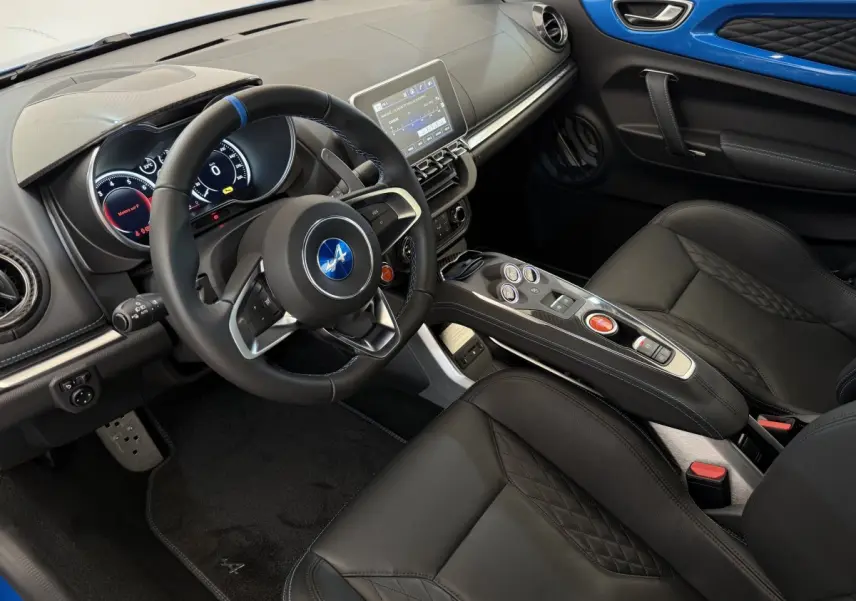 Vue intérieure côté conducteur de l'Alpine A110 Légende 2019, volant cuir avec bande bleue et inserts bleus sur porte.