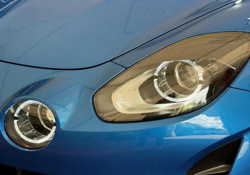 Gros plan sur les phares avant droit bleu de l'Alpine A110 Legende 2019 avec éclairage LED distinctif.