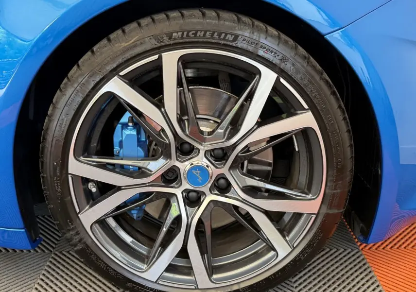 Gros plan sur la roue avant droite bleue d'une Alpine A110 Legende 2019 avec étrier de frein assorti.