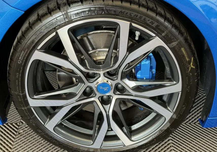 Gros plan sur la jante alu et l'étrier de frein bleu d'une Alpine A110 Legende 2019 bleu essence.