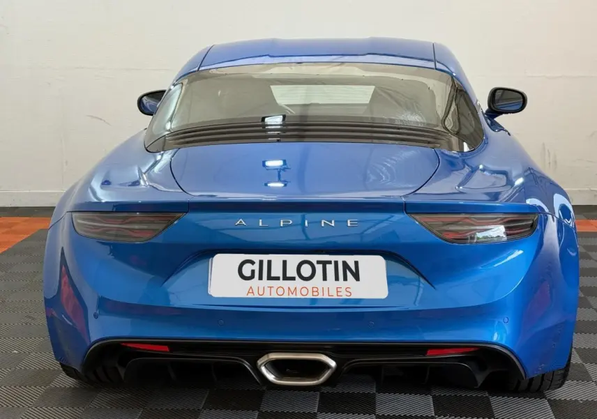 Vue arrière d'une Alpine A110 Legende bleu brillant, mettant en valeur ses feux effilés et son échappement central.