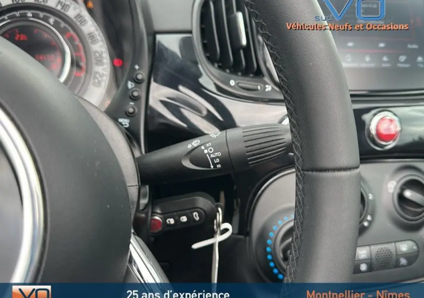 Intérieur noir de la FIAT 500C 2024, vue rapprochée du volant et des commandes côté gauche.