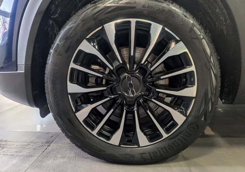 Gros plan sur la jante alliage bicolore noire et argentée du FIAT 500X Bleu Venezia, pneu Continental visible.