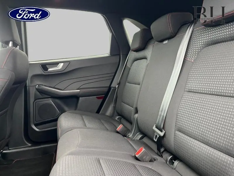 Vue intérieure côté droit des sièges arrière gris foncé du Ford Kuga 2023 avec ceintures et détails en surpiqûres rouges.