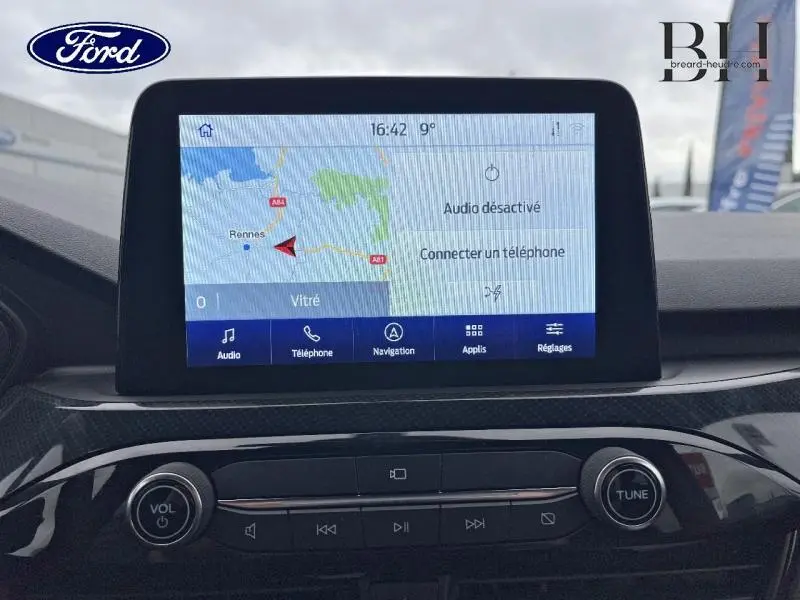 Écran tactile central du Ford Kuga 2023 gris Magnetic, affichant la navigation avec carte et options multimédia.