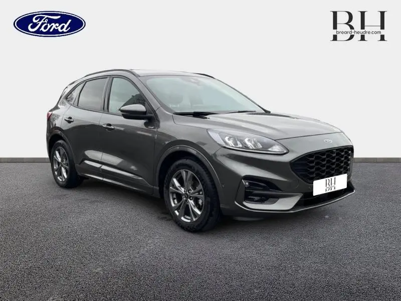 Ford Kuga 2023 gris Magnetic métallisé vu en 3/4 avant droit avec calandre noire et jantes alu sport.