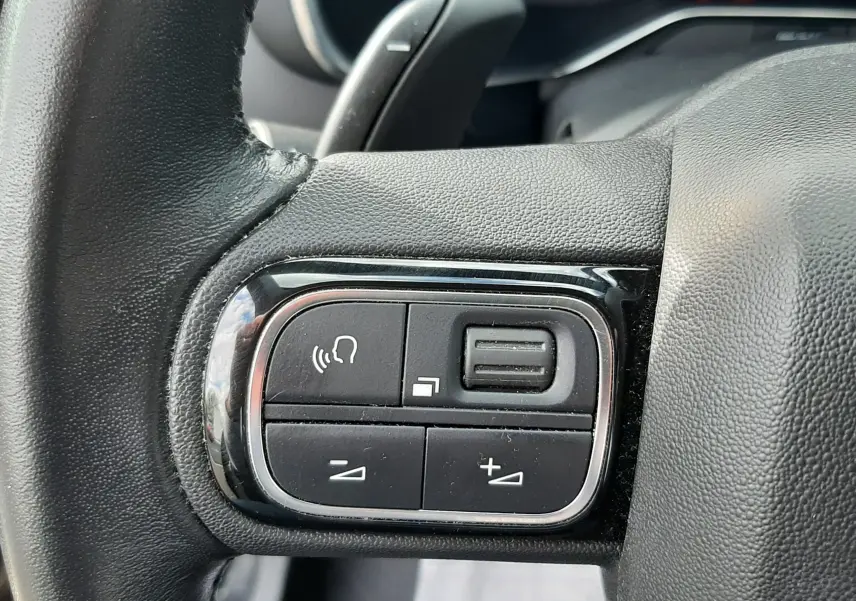 Gros plan sur les commandes gauche du volant noir du Citroën C5 Aircross 2020, avec boutons de volume et appel.