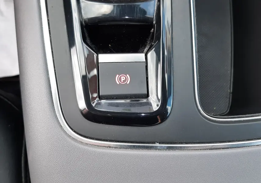 Gros plan sur le bouton de frein à main électronique rouge dans la console centrale noire du Citroën C5 Aircross 2020.