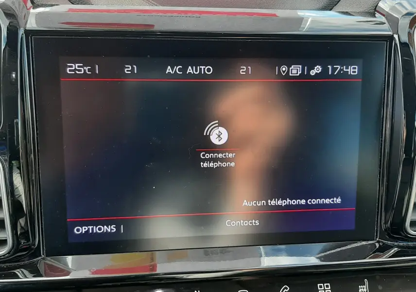 Écran tactile central du tableau de bord du Citroën C5 Aircross noir, affichant la connexion Bluetooth et la climatisation automatique.