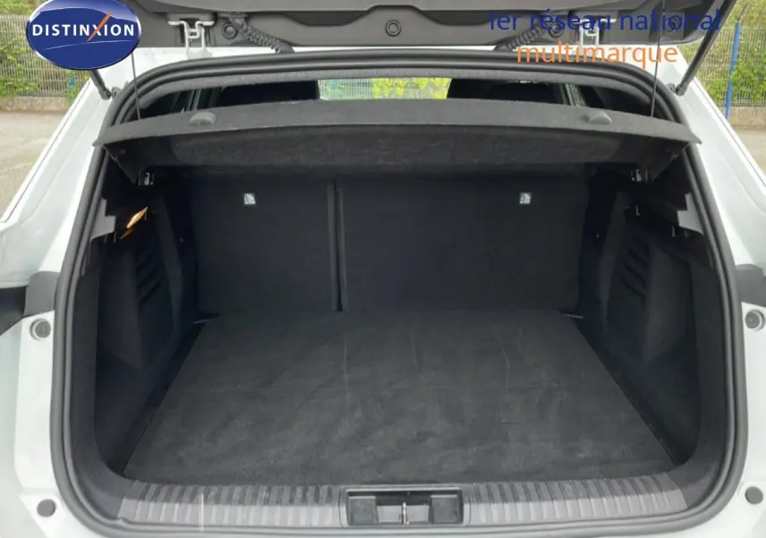 Coffre ouvert vu de l’arrière d’une Renault SYMBIOZ blanc nacré, montrant un espace de chargement spacieux et noir.