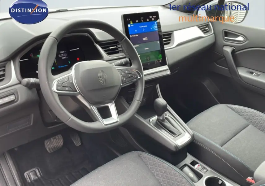 Vue intérieure avant de la Renault Symbioz E-Tech Full Hybrid 2025, tableau de bord moderne avec écran tactile vertical et volant cuir.