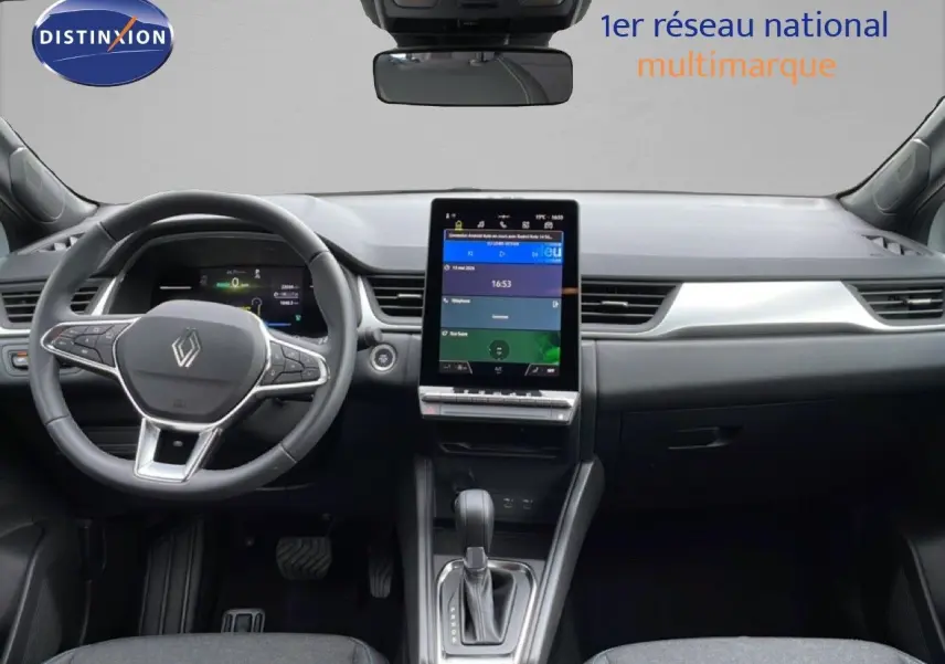 Vue intérieure avant du tableau de bord et volant du Renault Symbioz blanc nacré, avec écran tactile central vertical.