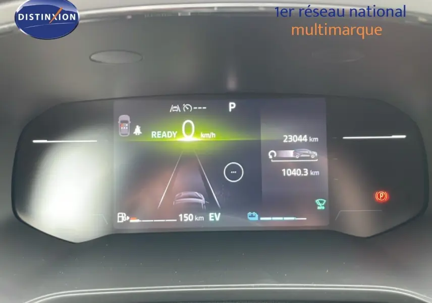 Tableau de bord numérique de la Renault Symbioz blanc nacré, affichant la vitesse à 0 km/h et l'autonomie électrique.