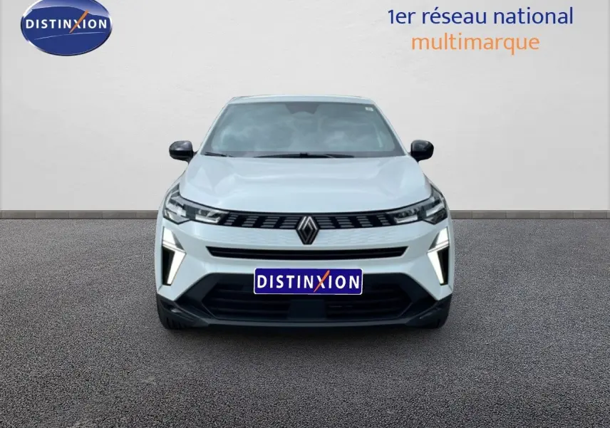 Vue avant d'une Renault Symbioz blanc nacré avec calandre noire et feux LED verticaux allumés sur un sol gris.