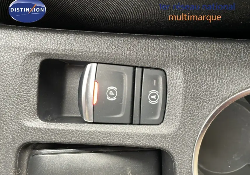 Vue rapprochée sur les commandes de frein à main électronique et auto hold dans l’habitacle d’une Renault Symbioz blanc nacré.