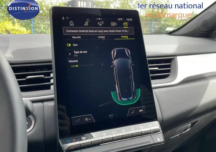 Vue intérieure du tableau de bord de la Renault Symbioz blanc nacré, écran tactile central affichant l'aide au stationnement.