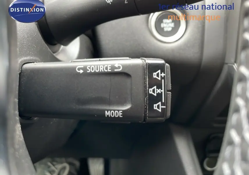 Gros plan sur la commande multifonction noire côté gauche du volant du Renault Symbioz blanc nacré, avec bouton start visible.