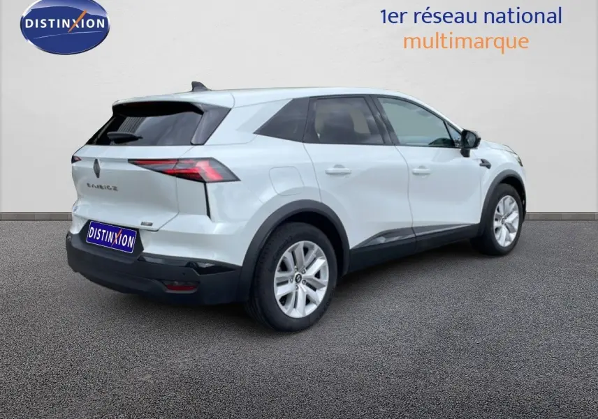 Vue 3/4 arrière droite d’un Renault Symbioz blanc nacré avec détails noirs et jantes argentées sur fond neutre.