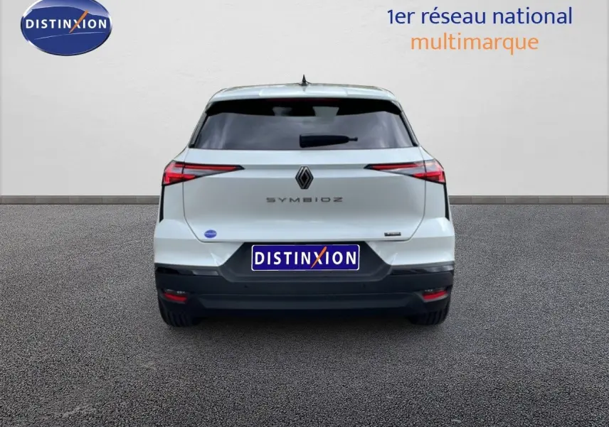 Vue arrière d'une Renault Symbioz blanc nacré métal, avec feux arrière étirés et logo central bien visible.