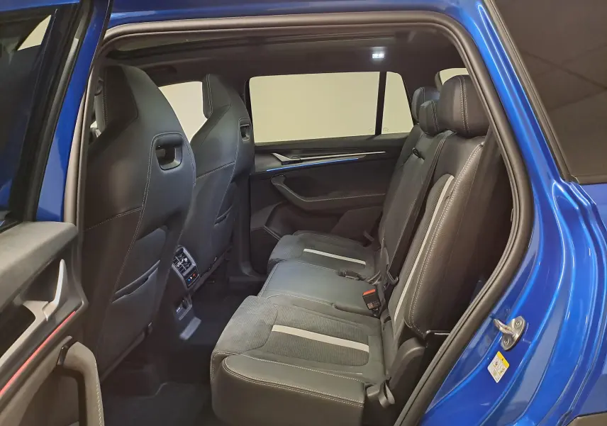 Vue intérieure côté droit sur la banquette arrière en cuir noir du Skoda Kodiaq Bleu RS avec toit panoramique ouvert.