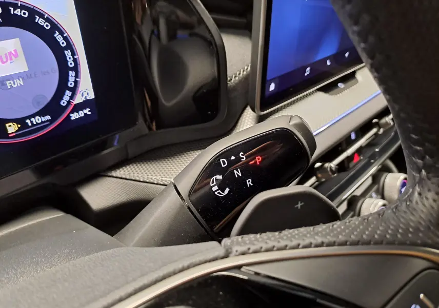 Gros plan sur la commande de boîte auto DSG7 du Skoda Kodiaq Bleu RS, avec tableau de bord numérique en arrière-plan.
