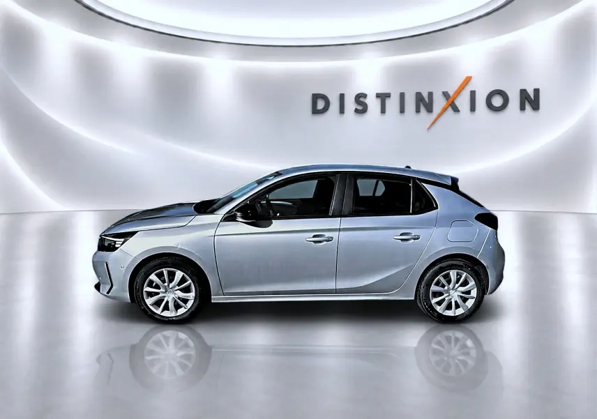 Opel Corsa gris vue de profil côté gauche, avec toit noir et jantes alliage, sur fond lumineux "DISTINXION".