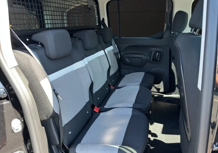 Vue latérale intérieure sur la banquette arrière grise et noire du Citroën Berlingo noir avec séparation métallique.