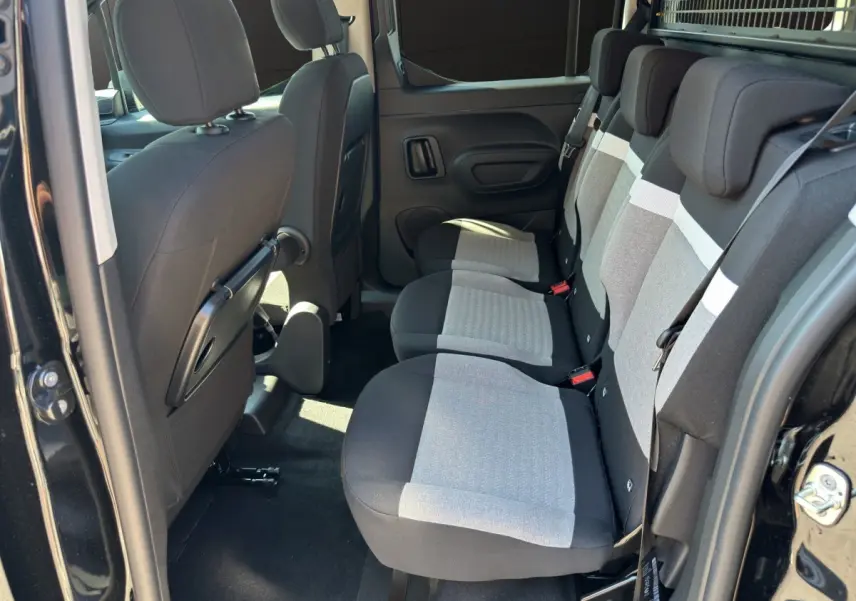 Intérieur arrière du Citroën Berlingo noir 2026, vue côté droit sur banquette 3 places grise et noire.