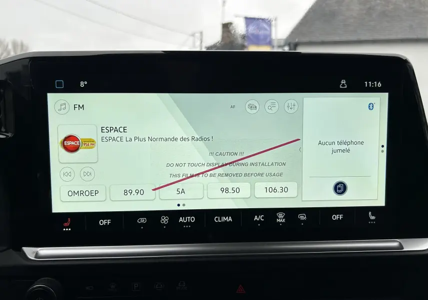 Écran tactile central du Volkswagen Transporter T7 ProCab affichant la radio FM et les commandes de climatisation.