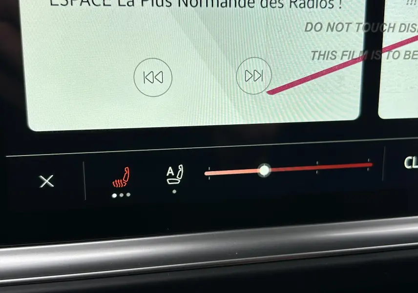Gros plan sur l'écran tactile intérieur du Volkswagen Transporter T7 Business, affichant les commandes de siège chauffant et de réglage.