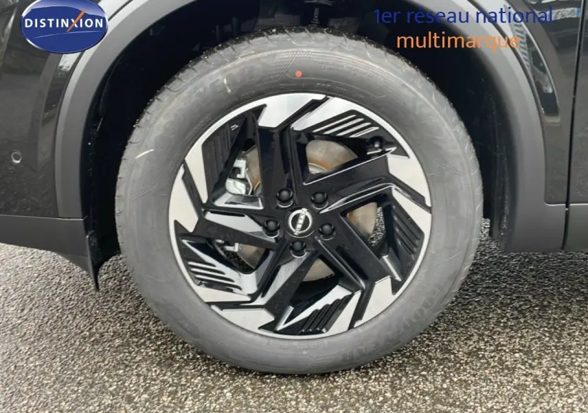 Gros plan sur la roue avant gauche du Nissan Qashqai 2025 noir perle métal avec jante alliage bicolore.