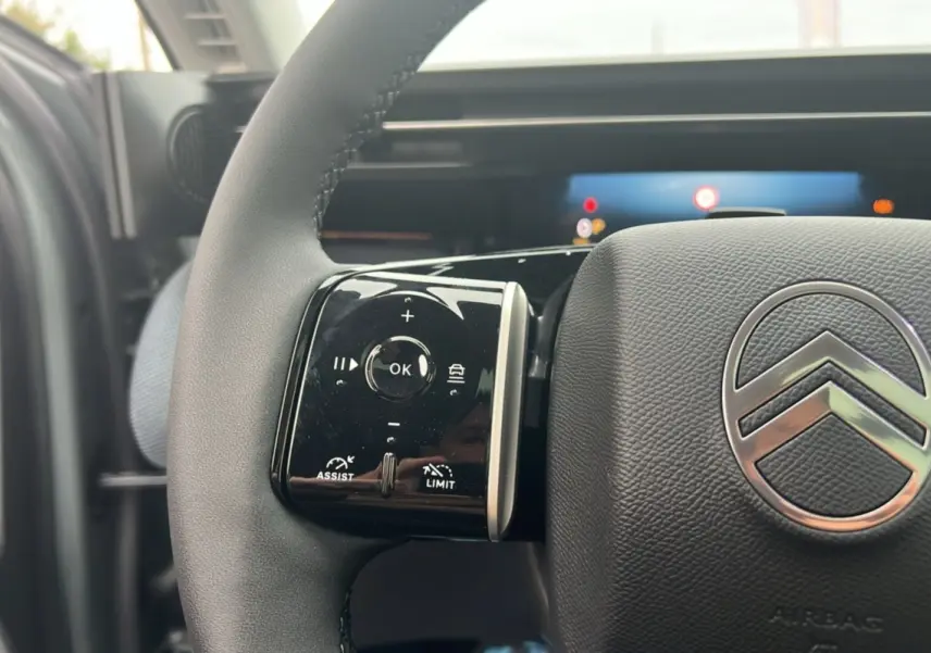Gros plan sur le volant cuir multifonctions Citroën C5 Aircross New Hybrid, avec commandes intégrées et logo chromé central.