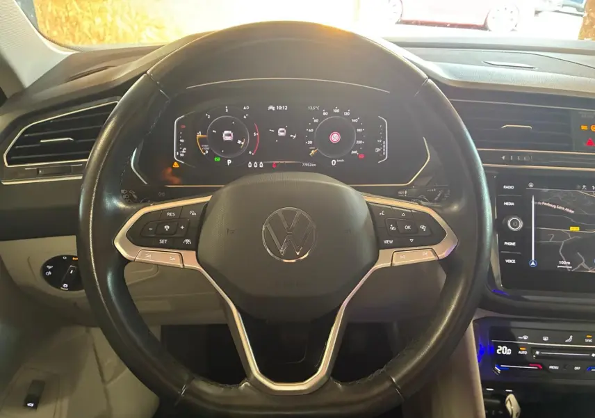 Vue rapprochée du volant noir du Volkswagen Tiguan 2023 avec tableau de bord digital et écran tactile de navigation.