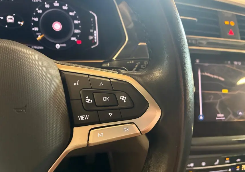 Gros plan sur le volant multifonctions en cuir du Volkswagen Tiguan 2023 avec écran digital et commandes intégrées.