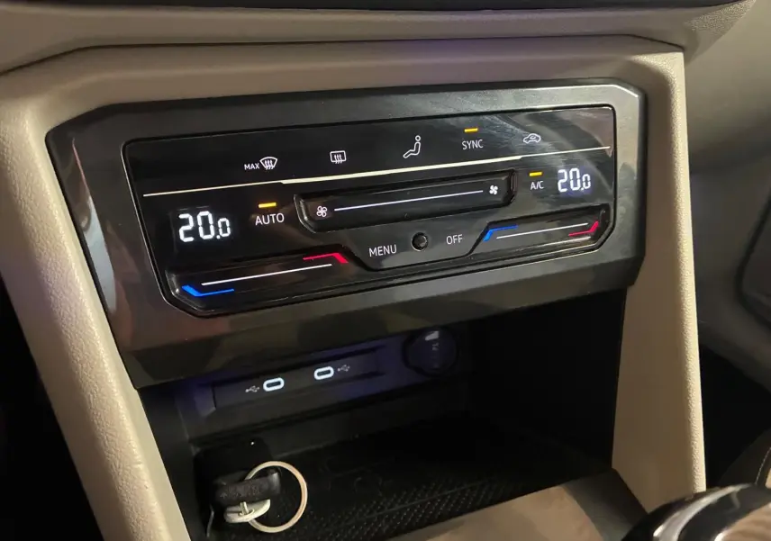 Gros plan sur la console centrale du Volkswagen Tiguan gris 2023, affichant la climatisation automatique à 20°C.