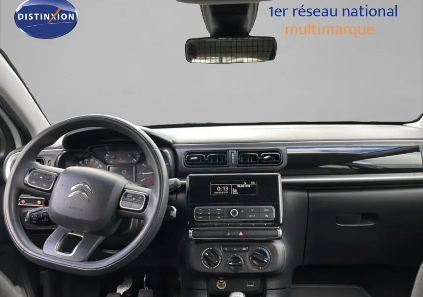 Vue intérieure avant du tableau de bord noir et gris d'une Citroën C3 Société blanche avec volant multifonction et écran central.